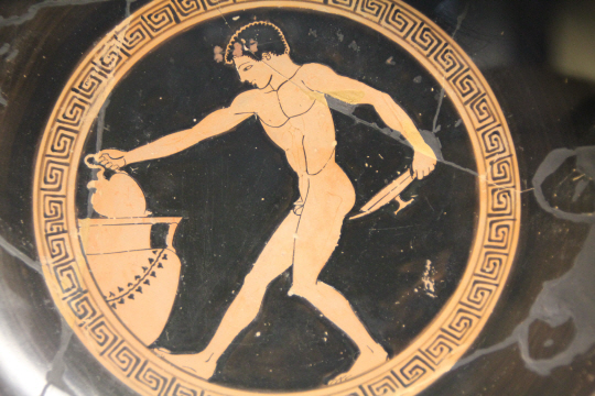 프랑스 파리 루브르 박물관의 BC 6세기 그리스 도자기. 한 남성이 심포지온 중 포도주의 농도를 조절하는 장면이다.