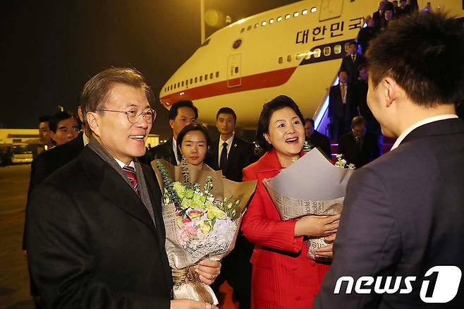 중국을 국빈 방문중인 문재인 대통령이 15일 오후(현지시간) 충칭 장베이 공항에 도착해 환영인사에게 꽃다발을 받고 있다.(청와대 제공) 2017.12.16/뉴스1 © News1 이광호 기자