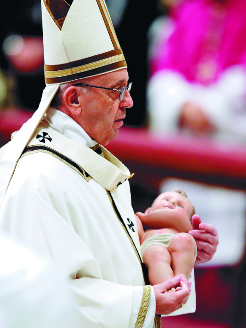 프란치스코 교황이 24일(현지시간) 바티칸 성 베드로 대성당에서 열린 성탄전야 미사에서 아기예수상을 들고 있다.AP뉴시스
