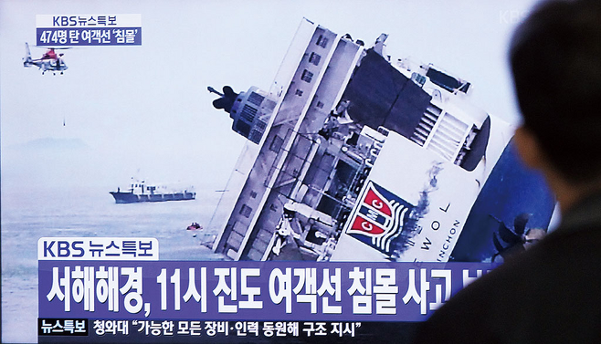2014년 4월16일 서울역에서 세월호 침몰 방송을 시민들이 안타깝게 바라보고 있다. © 사진=AP연합
