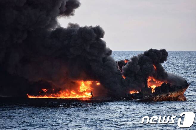 한국으로 향하다 중국 동중국해에서 침몰한 이란 유조선 '상치호'의 불을 끄기위해 10일 중국 보급선이 물을 뿌리는 장면.© AFP=뉴스1