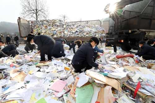 쓰레기 더미 속에서 문서 찾고 있는 수자원공사 직원들