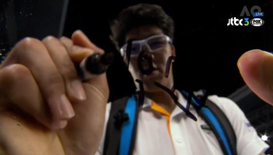 정현이 2018 호주오픈 8강에 진출한 후, 중계 카메라 렌즈에 자신의 사인 대신 메시지를 적고 있다. [사진 JTBC3 FOX Sports 캡처]