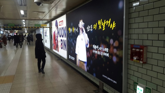 지난 21일 서울 삼성역에 걸린 아이돌 응원 광고를 지나가는 한 시민이 바라보고 있다. 임선영 기자
