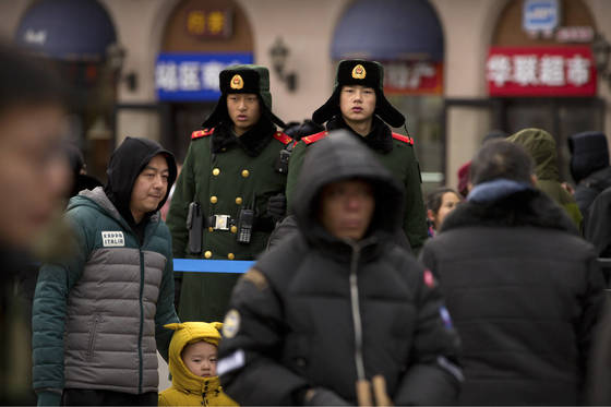 지난달 9일 춘절을 맞아 인파가 몰린 베이징역 인근에서 중국 공안이 경계 근무를 서고 있다. [베이징 AP=연합뉴스]