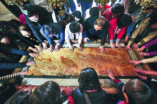 예수를 염(殮)한 곳으로 알려진 석판 위에 순례객들이 손을 올린 채 기도하는 모습. 새에덴교회 제공
