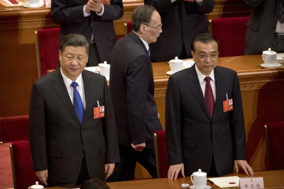 18일 중국 베이징 인민대회당에서 열린 13기 전국인민대표대회(전인대) 전체회의에 참석한 시진핑 중국 국가주석(왼쪽 첫번째)과 리커창 총리(왼쪽 세번째) 뒤를 왕치산 국가 부주석이 지나가고 있다. AP연합뉴스