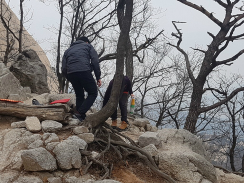 지난 13일 국립공원 내 음주행위가 금지된 이후 맞은 첫 주말인 17일 오후 서울 북한산 국립공원에서 막걸리를 마시던 등산객이 술병을 급히 치우고 있다.