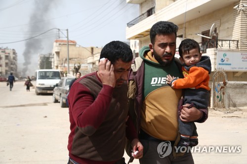 포연이 솟는 아프린을 뒤로 하고 도시를 벗어나는 시리아 가족 [AFP=연합뉴스]