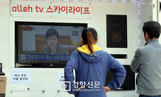 세월호 침몰 사건 엿새째인 2014년 4월  21일 전남 진도 실내체육관 앞에서 실종자 가족이 텔레비전을 통해 박근혜 대통령의 발언을 듣고 있다. /강윤중 기자