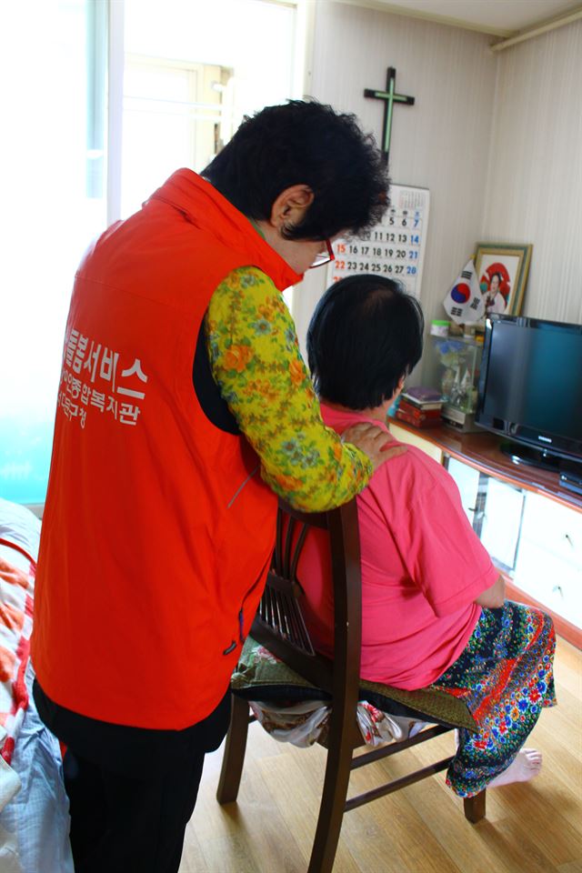 권옥선(왼쪽) 독거노인 도우미가 ‘장애인의 날’인 지난 20일 서울 홍제동의 독거노인 이숙자(가명)씨 집을 방문해 안마를 해주고 있다.