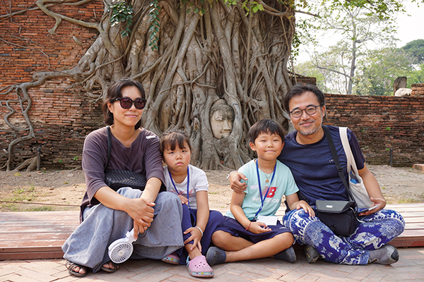 ⓒ구완회 타이 방콕 북부 아유타야의 상징인 ‘나무뿌리 속 부처머리상’ 앞에서 찍은 구완회씨(맨 오른쪽) 가족사진.