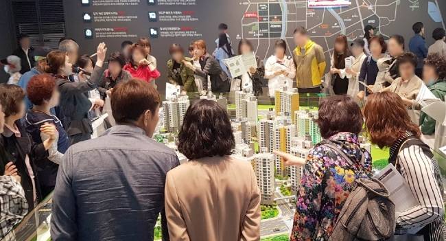 앞으로 분양대행업체가 분양상담, 청약접수 등을 하려면 건설업 면허가 있어야 한다. 지방의 한 아파트 견본주택에서 방문객이 아파트 모형을 살펴보고 있다.