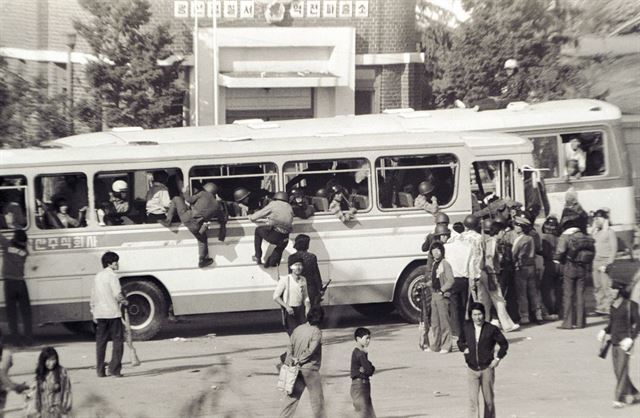 광주 송정리역 광장에서 소총으로 무장한 시민군이 금남로로 향하는 버스에 앞다투어 올라타고 있다.