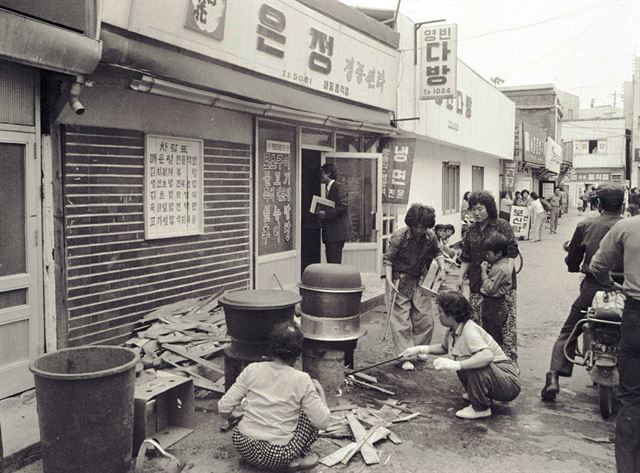 5월 20일 금남로에서 치열한 투석전이 벌어지는 동안 골목 식당 앞에선 시민들이 큰 솥을 걸고 시민군에게 줄 주먹밥을 만들고 있다.