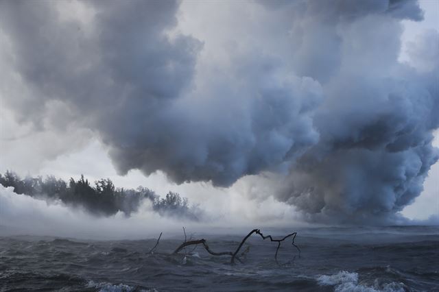 하와이섬 킬라우에아 화산에서 용암과 화산재 분출이 2주가 넘도록 이어지고 있는 가운데 20일(현지시간) 파호아 부근에서 용암이 바다로 흘러들어가자 거대한 유독가스 연기가 피어오르고 있다. AP 연합뉴스