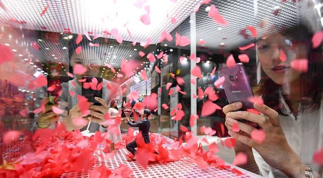 삼성전자부스에서 관람객이 스마트폰 S9으로 슈퍼 슬로우 모션을 시연해보고 있다.