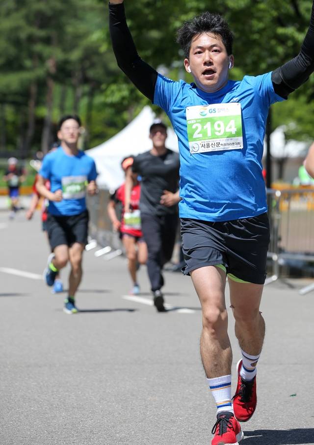 2018년 5월19일 서울 마포구에서 열린 서울신문하프 마라톤대회에 참가한 이재호 기자가 결승점을 들어오며 두 손을 번쩍 들어 보이고 있다. 서울신문하프마라톤대회 누리집