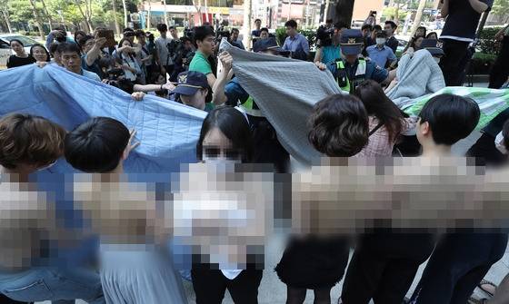 불꽃페미액션 활동가들이 2일 오후 서울 강남구 페이스북코리아 사옥 앞에서 성차별적 규정에 맞서는 상의탈의 퍼포먼스를 벌이다 경찰에게 제지 당하고 있다. /사진=뉴스1