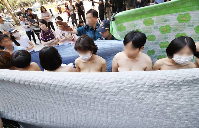 2일 오후 서울 강남구 페이스북코리아 앞에서 여성단체 ‘불꽃페미액션’ 회원들이 페이스북의 성차별적 규정에 항의하는 상의 탈의 시위를 하고 있다. 이 단체는 앞서 페이스북이 남성의 반라 사진은 그대로 두면서 여성의 반라 사진만 삭제하는 점을 규탄하기 위해 기자회견을 열었다고 밝혔다. (제공=연합뉴스)