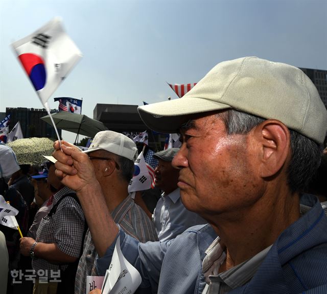 6일 오후 서울 종로구 교보빌딩 앞에서 열린 '자유민주주의 수호 국민대회'에서 참가자들이 태극기를 흔들고 있다. 배우한 기자