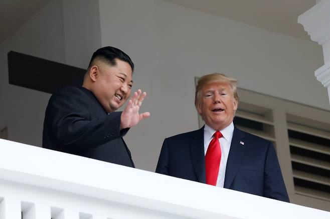 발코니에 나란히 김정은 국무위원장이 도널드 트럼프 대통령과 대화하다 취재진을 향해 웃으며 손을 흔들고 있다.   로이터연합뉴스