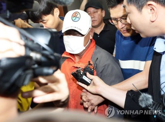 전북 군산시 장미동 한 주점에 불을 지른 혐의로 긴급체포된 이모(55)씨가 18일 새벽 병원 치료를 받기 위해 군산경찰서를 나가고 있다.사진=연합뉴스