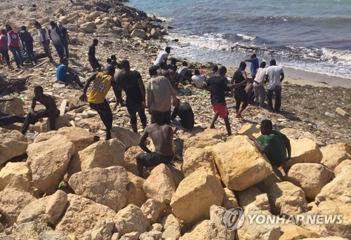 20일(현지시간) 침몰하던 고무보트에서 구조된 난민, 이주자들이 리비아 해안에서 쉬고 있다. [AP=연합뉴스]
