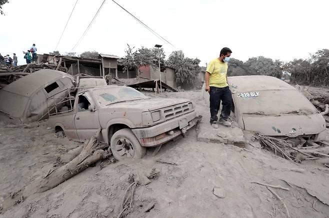 콰테말라 푸에고 화산 폭발로 피해를 입은 차량을 지난 5일 현지 주민이 둘러보고 있다. [Xinhua=연합뉴스]