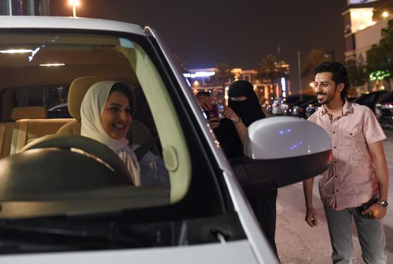 사우디 한 여성과 남성이 24일(현지시간) 리디야 시내를 처음으로 운전한 사마르 알 모겐을 응원하고 있다. [AFP=연합뉴스]