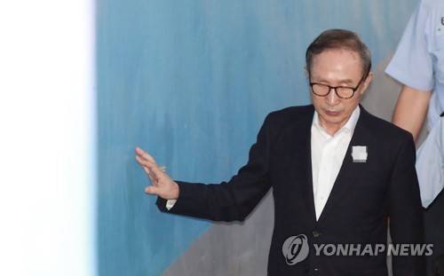 벽에 손대며 공판 출석하는 이명박 (서울=연합뉴스) 한종찬 기자 = 110억원대 뇌물수수와 350억원대 다스 횡령 등 혐의로 구속기소 된 이명박 전 대통령이 12일 오전 서초구 서울중앙지방법원에서 열린 속행 공판에 출석하기 위해 호송차에 내려 법정으로 향하고 있다. 2018.7.12 saba@yna.co.kr