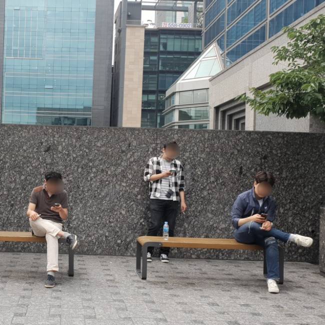 서울 강남구의 한 건물 앞에 마련된 흡연구역에서 담배 피는 사람들의 모습. 이현정 기자/rene@heraldcorp.com