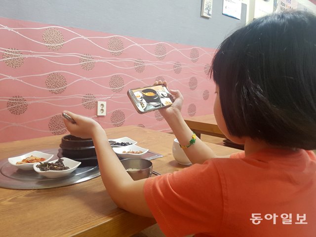 13일 서울 노원구의 한 음식점에서 윤주가 유튜브에 올릴 저녁 식사 장면을 찍고 있다. 신규진 기자 newjin@donga.com