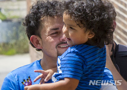 【AP/뉴시스】 온두라스에서 온 불법이민자 에버 레이에스 메지아가 이민국 앞에서 다시 만난 3살짜리 아들을 안고 기뻐하고 있다. 사진은 미국 이민세관단속국(ICE)가 제공한 것이다. 2018.07.11