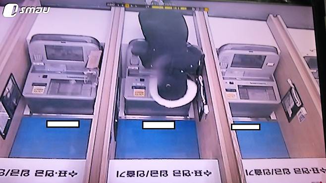 체크카드 사기 일당 중 한 명이 돈을 인출하는 모습. (서울지방경찰청 외사과 국수3대 제공) © News1