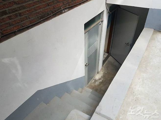 다나카씨의 집으로 가는 길. 시멘트 벽으로 둘러싸인 계단을 내려가면 형광등 없인 어둑한 방에 들어서게 된다. 김명지 기자