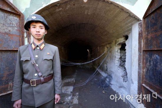 24일 북한 핵무기연구소 관계자들이 함경북도 길주군 풍계리 핵실험장 폐쇄를 위한 폭파 작업을 했다. 북한 군인이 핵실험장 3번 갱도 앞을 지키고 있다./사진공동취재단