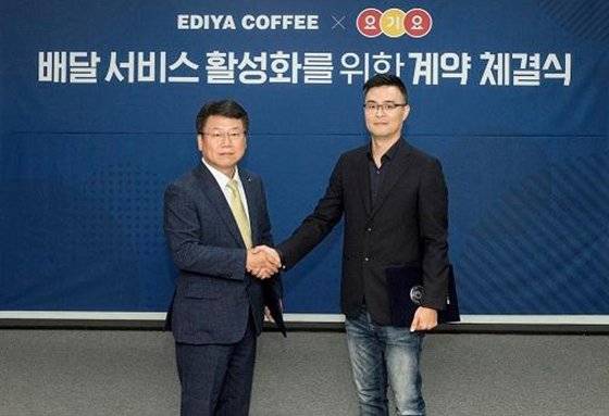 이디야커피 최홍수 부사장(왼쪽)과 요기요 박해웅 부사장이 지난 23일 서울 논현동 이디야커피 본사에서 배달 서비스 활성화를 위한 계약 체결을 하고 있다.