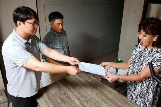 지난달 30일 오후 8시30분께 A씨(사진 오른쪽)가 입주자대표회의 회장 B씨(사진 왼쪽)에게 자필로 작성한 사과문을 건내고 있다.사진/H아파트 관리사무소 제공