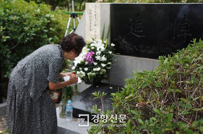 한 일본인 여성이 지난 1일 간토대지진 조선인희생자 추도비에 헌화한 뒤 추도비 내용을 적고 있다. 도쿄|김진우 특파원
