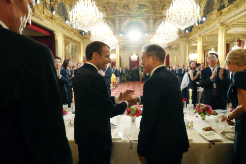 문재인 대통령이 15일(현지시간) 프랑스 파리 대통령궁에서 열린 국빈만찬에서 에마뉘엘 마크롱 프랑스 대통령과 건배한 후 악수하고 있다.