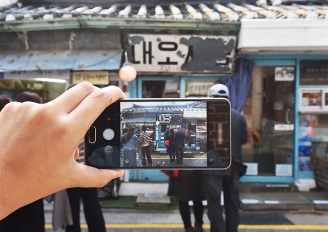 16일 서울 서촌을 찾은 방문객이 스마트폰으로 대오서점을 촬영하고 있다