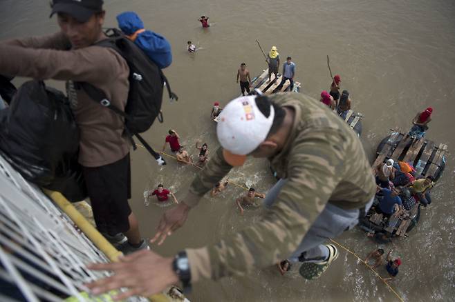 콰테말라 국경 테쿤 우만 다리 위에서 수치아떼 강으로 뛰어드는 온두라스 이민자들. AP=연합뉴스