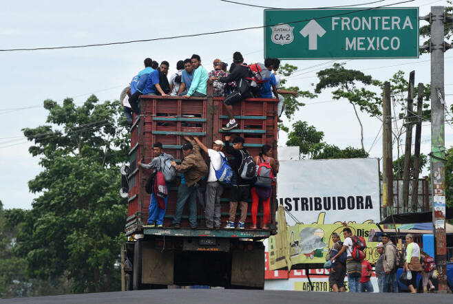 과테말라 테쿤 우만에서 멕시코로 향하는 트럭에 매달린 온두라스 이민자들. AFP=연합뉴스