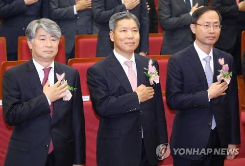 한자리에 앉은 신임 재판관들 (서울=연합뉴스) 한상균 기자 = 18일 오후 헌법재판소에서 열린 취임식에서 신임 재판관들이 국기에 대한 경례를 하고 있다. 왼쪽부터 이종석, 이영진, 김기영 신임 헌법재판관. 2018.10.18 xyz@yna.co.kr (끝)