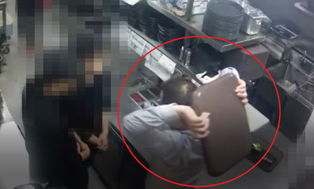 교촌치킨 권모 신사업본부장(당시 사업부장)이 직원 두 명을 쟁반으로 때리려는 자세를 취하고 있다./ CCTV 캡처