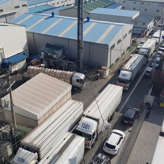 지난 5일 화물연대 울산지부 소속 기사들이 트럭으로 성우하이텍 공장 인근 도로를 가로막은 모습. [사진 국제신문]