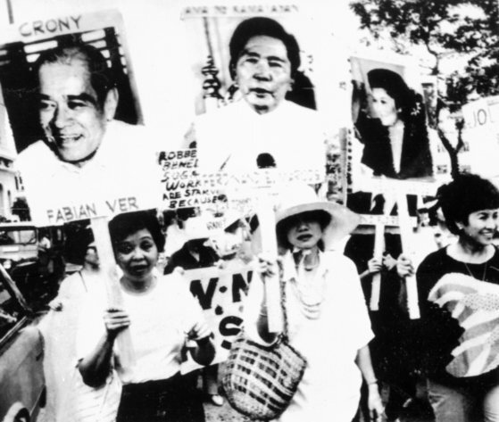 1986년 필리핀 시민들이 마르코스 대통령과 부인 이멜다의 초상화를 들고 시위를 하고 있다. [중앙포토]