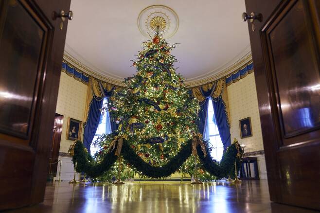 6m 높이의 백악관 공식 크리스마스 트리가 블루룸에 설치됐다. 각 주와 지역 이름을 금실로 수 놓은 150m가량의 푸른 벨벳 리본이 휘감고 있다. [AP=연합뉴스]