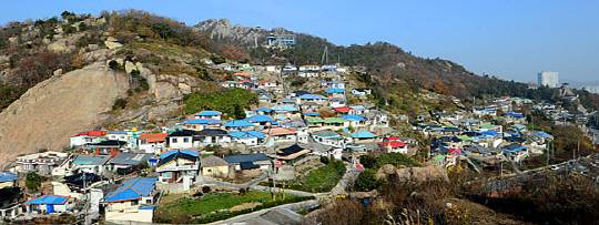 목포 아리랑고개에서 본 유달산 아래 온금동의 모습. 사진 왼쪽 아래 아리랑고개 너머 조선내화 목포공장이 있다. 온금동은 조선내화 공장이 만든 동네다. 다닥다닥 붙은 집 뒤편 유달산 정상 아래에 건설 중인 케이블카 상부 정류장이 보인다.